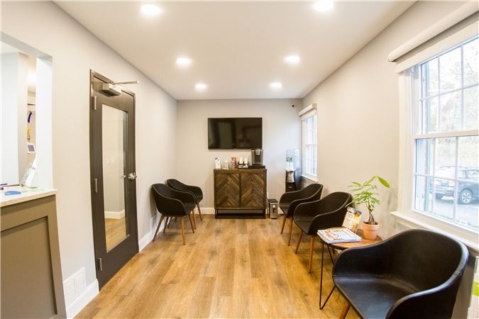 Seating area with chairs and indoor plants in waiting room, part of dental clinic interior in green village, nj services provided at Vaccaro Aesthetic and Family Dentistry in Green Village, NJ.