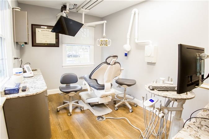 Dental operatory with chair and mounted monitors, part of orthodontics in green village, nj services provided at Vaccaro Aesthetic and Family Dentistry in Green Village, NJ.