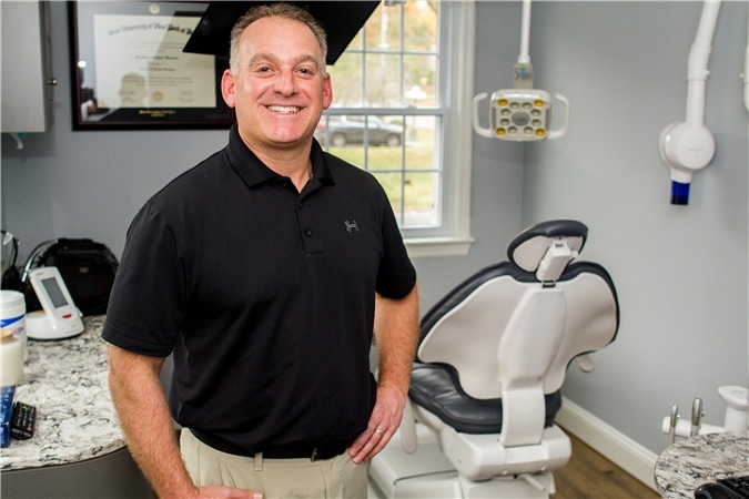 Male dentist smiling inside operatory room, part of general dentistry in green village, nj services provided at Vaccaro Aesthetic and Family Dentistry in Green Village, NJ.